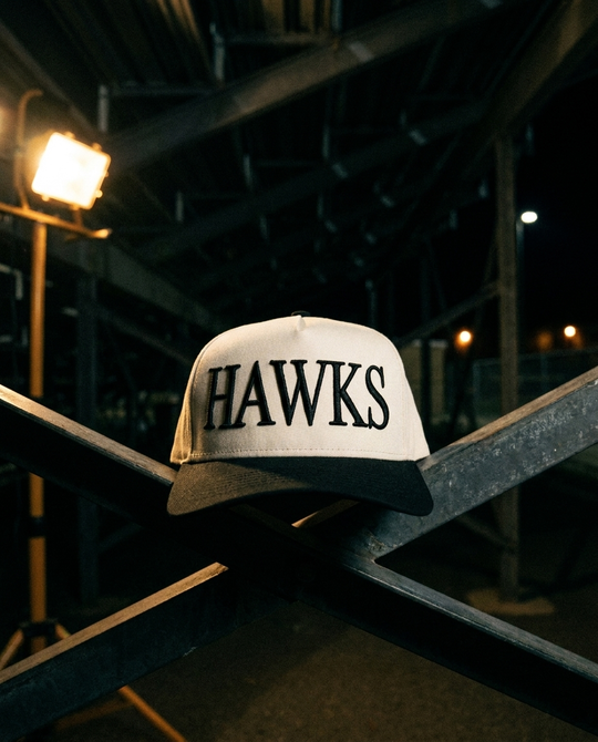 CRBKBK Heath Hawks big puff hat, cream crown, black brim, black raised puff embroidery, under the bleachers at night in Rockwall Texas