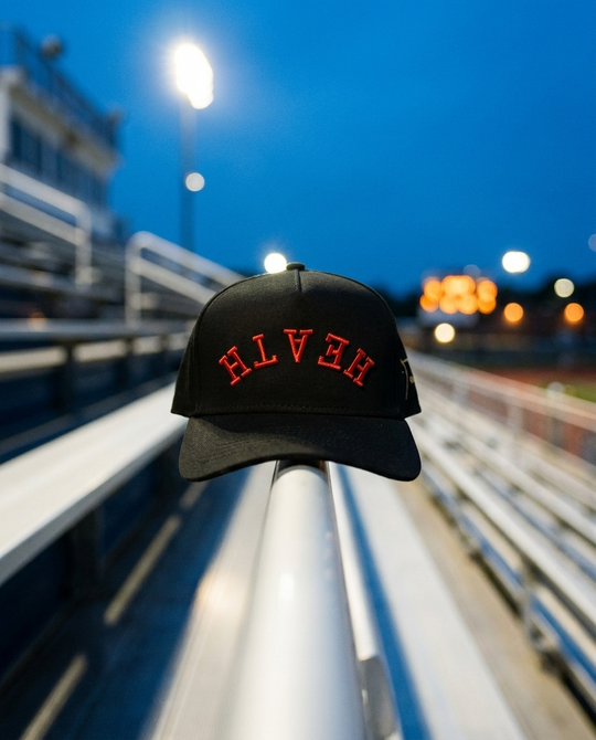BKBKRD Heath upside down hat, black crown, black brim, red embroidery, on a stadium handrail at blue hour in Rockwall Texas