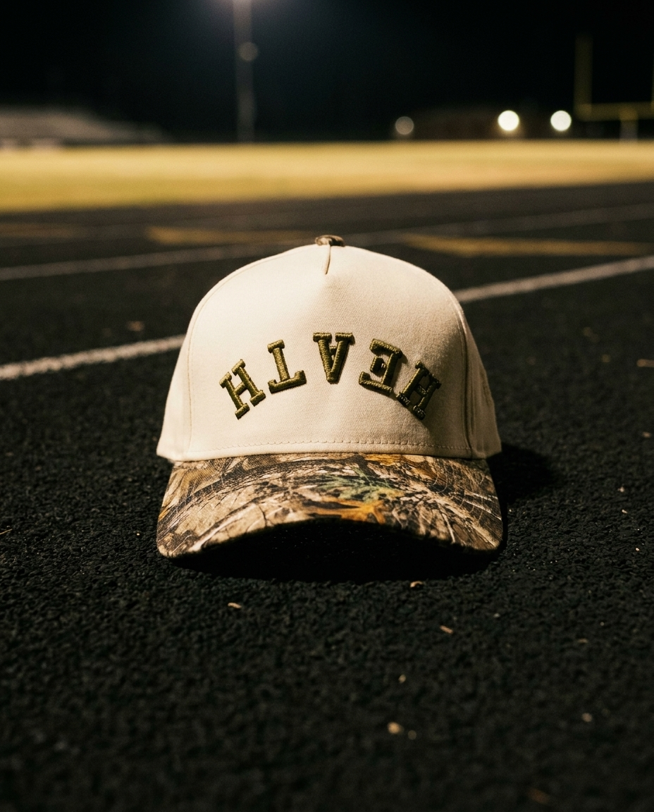 CRCMGN Heath upside down hat, cream crown, camo brim, green embroidery, trackside at night in Rockwall Texas