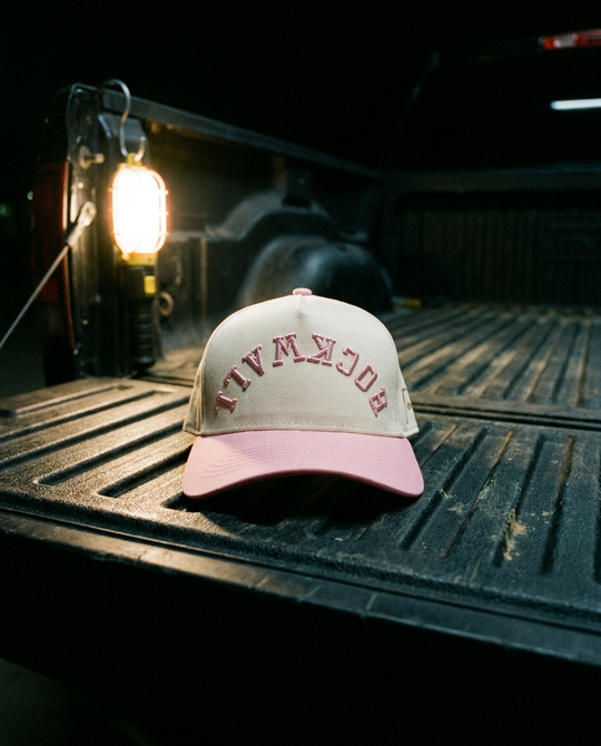 CRPKPK Rockwall upside down hat, cream crown, pink brim, pink embroidery, in a truck bed at night in Rockwall Texas