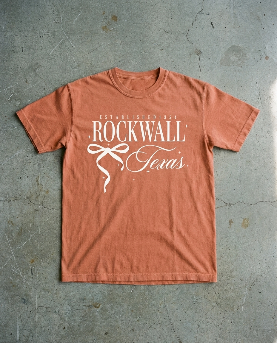 Rockwall Bow So Cute tee in terracotta, ESTABLISHED 1854 over ROCKWALL with a ribbon bow and Texas in script, garment dyed Comfort Colors