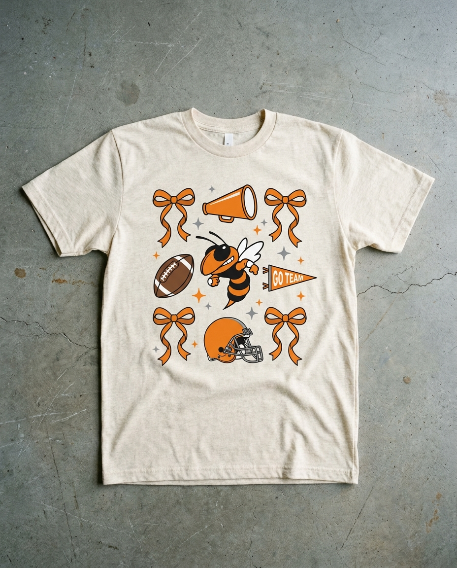 Rockwall Spirit Checkered tee in natural heather, bows, megaphone, football, hornet, helmet and a GO TEAM pennant scattered across the chest