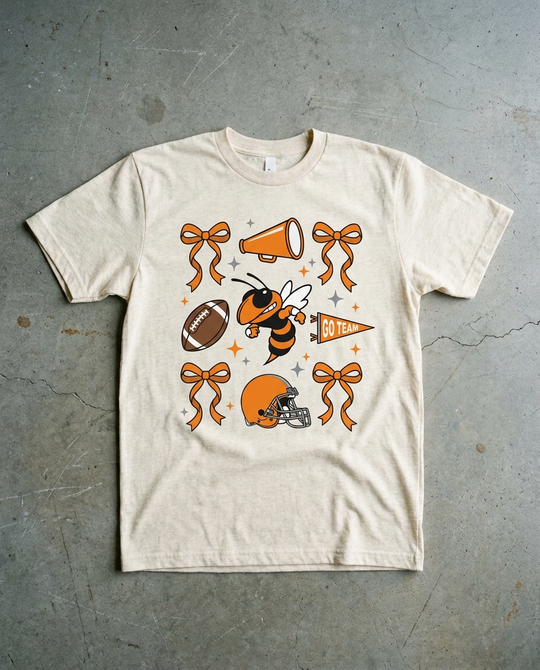 Rockwall Spirit Checkered tee in natural heather, bows, megaphone, football, hornet, helmet and a GO TEAM pennant scattered across the chest